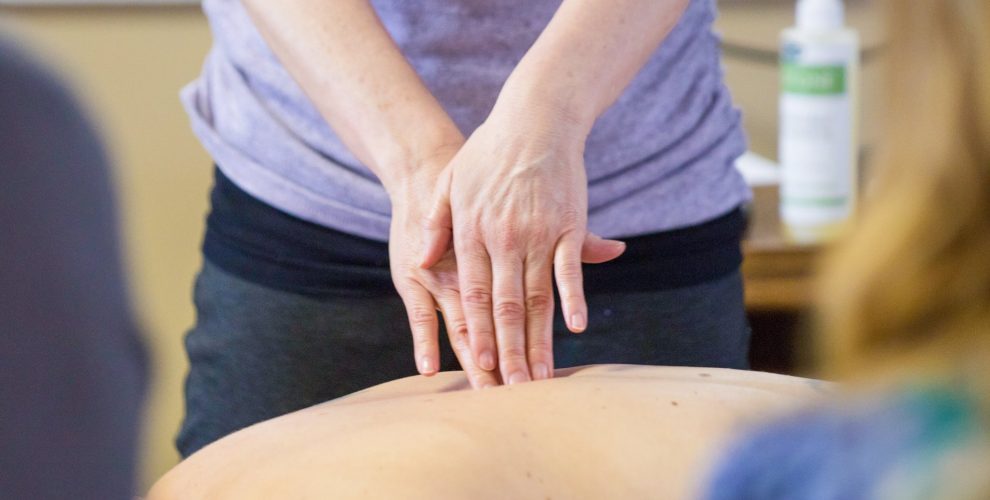 The Lakewood School of Therapeutic Massage students gathered around Instructor Y...